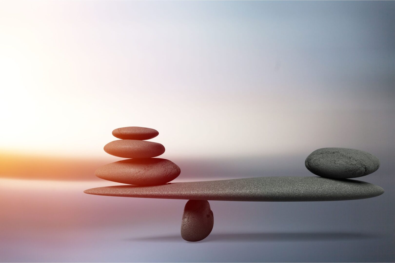 A balanced balance with three stones stacked on top of each other.