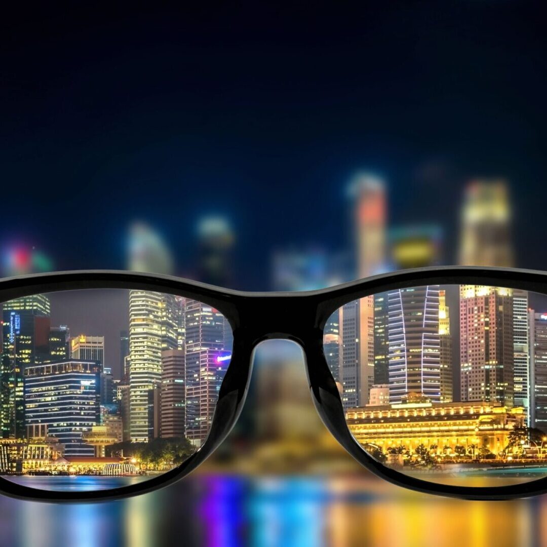 A pair of glasses with the city skyline in the background.